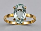 an oval aqua blue topaze ring with a gold band