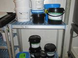 many buckets and containers on a shelf in the kitchen