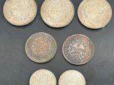 six different coins sitting on top of a table next to each other