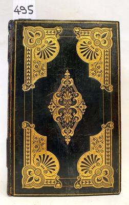a black and gold book sitting on top of a white table
