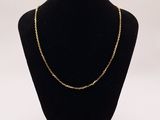 a black mannequin with a gold chain on it