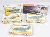 plusieurs boîtes contenant des maquettes d'avions de différents modèles, posées sur une surface blanche