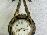 une horloge accrochée au mur, ornée d'un nœud