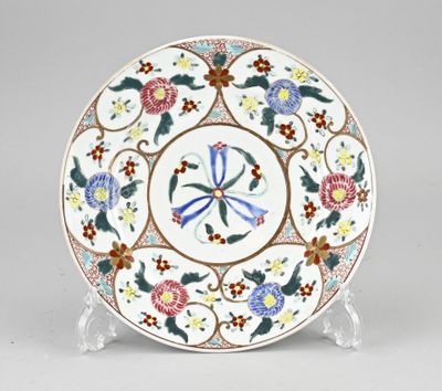 un gros plan d'une assiette décorée de fleurs, posée sur un support