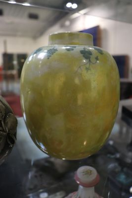 un vase jaune posé sur une table en verre dans une pièce