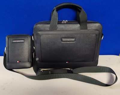 une photo montrant un sac noir et un téléphone portable posés sur une table