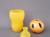 un vase jaune et un autre vase jaune placés l'un à côté de l'autre