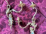 pair of antique brass wall sconces on a purple floral background