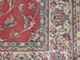 an image of a red and blue rug on a wooden floor