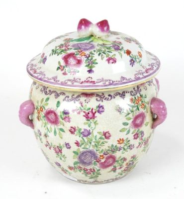a white vase with a pink handle and flowers on it