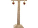 a close up of a pair of earrings on a stand