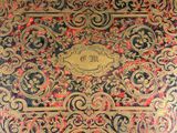 an old book with gold and red designs on a black background