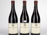 trois bouteilles de vin rouge posées sur une table blanche