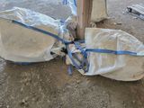 a bag of bags tied to a pole on the ground