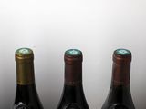 three bottles of wine are lined up on a table