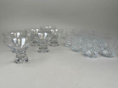 six verres à pied en verre transparent sont alignés sur une surface blanche