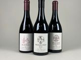 trois bouteilles de vin rouge sont alignées sur une table