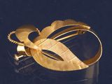 gros plan d'un bracelet en or sur une surface noire
