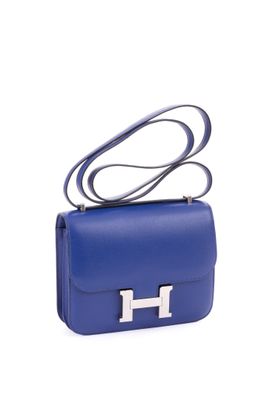 a blue handbag with a silver h on the handle