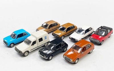 plusieurs petites voitures sont alignées sur une surface blanche