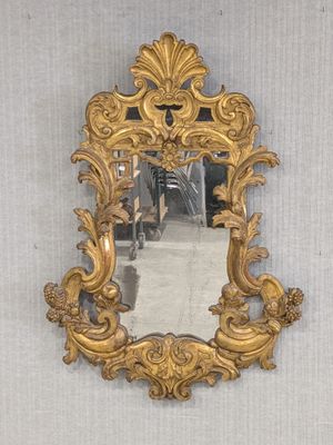un miroir accroché au mur avec un cadre doré