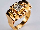 gros plan d'une bague en or avec un diamant au centre