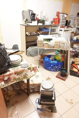 une cuisine en désordre, avec beaucoup de choses qui traînent par terre