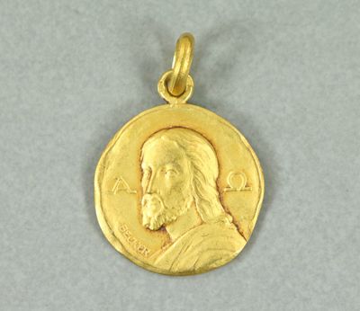 un gros plan d'une pièce d'or sur laquelle figure le visage de Jésus