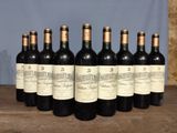 six bottles of wine are lined up on a wooden table