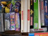 une boîte remplie de jeux, avec une peluche posée dessus