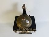 a metal bell on a stand with a tag on it