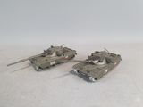 two toy tanks sitting side by side on a white surface