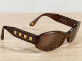 sunglasses on a wooden table with a white wall in the background