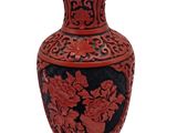 a red vase with black and red designs on it