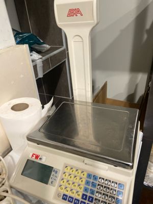une balance posée sur une table, à côté d'un rouleau de papier toilette