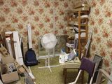 une pièce équipée d'un ventilateur, d'une chaise, d'une table et d'autres objets