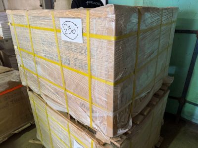 a man standing behind a stack of boxes in a warehouse