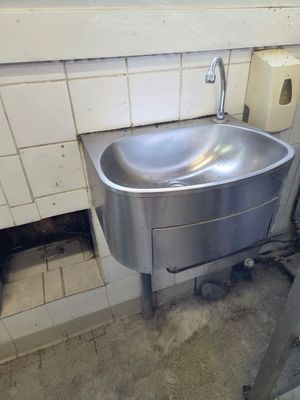 a sink in the corner of a public restroom