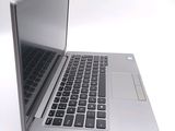 a silver laptop with a black keyboard on a white surface