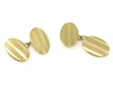 une paire de boutons de manchette plaqués or sur fond blanc