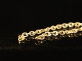 a close up of a gold chain on a black surface