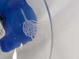 a blue bear in a glass bowl with a white background