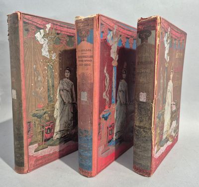 trois vieux livres sont empilés sur une surface blanche
