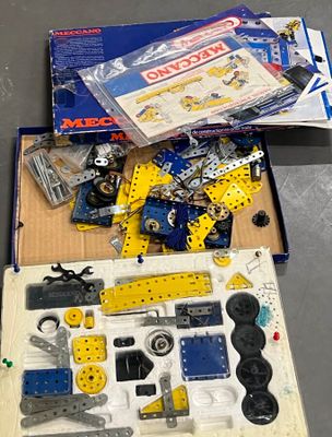 une boîte remplie de Lego et d'autres jouets posée sur une table