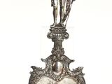 a silver figurine of a man on top of a heart