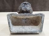a statue of a dog sitting on top of a box