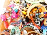 un tas de bijoux en tout genre posé sur une table en bois