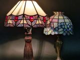 two lamps sitting on a table next to each other on a wall