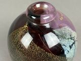 a purple vase with gold and black designs on it
