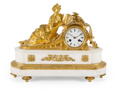 une horloge dorée et blanche sur laquelle figure une femme